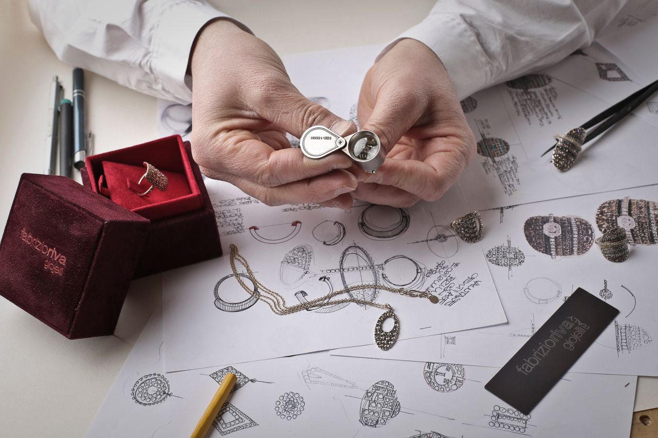 Jeweler inspecting a ring with a loupe to verify authenticity before auction